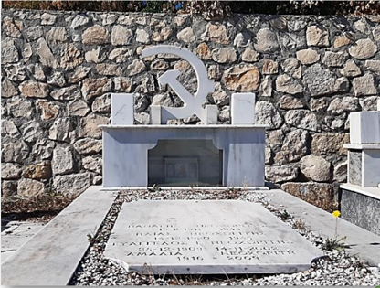 Grave in a cemetery. Α marble hammer and sickle as the central symbol at the top of a low stele.